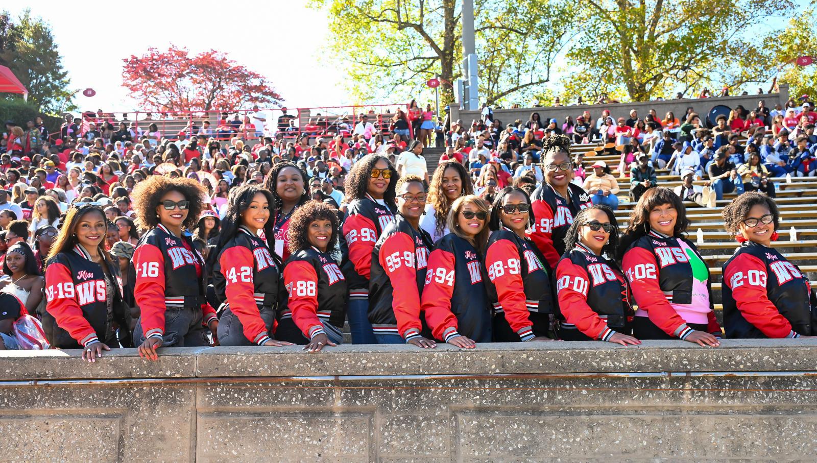 Alumnae queens in Miss WSSU letterman jackets lined up at Homecoming