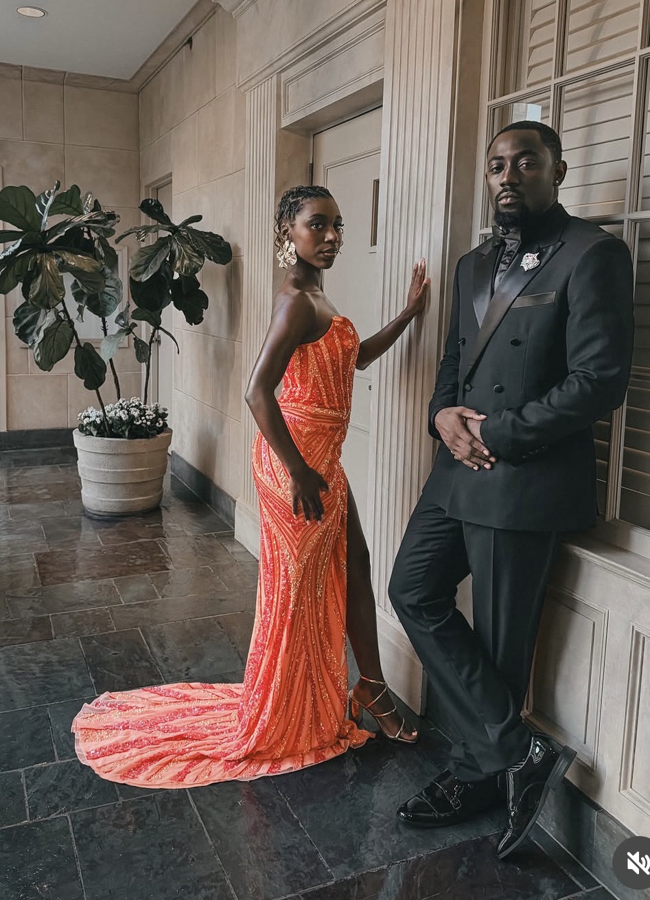 Queen in an orange sequined gown at a formal event